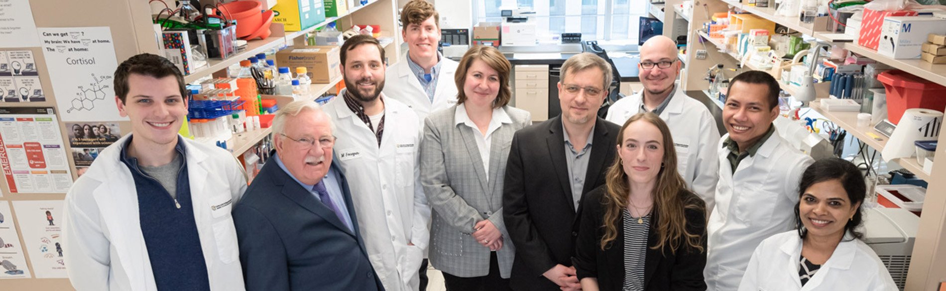Calla Winchell poses with her large care team in a lab on campus.
