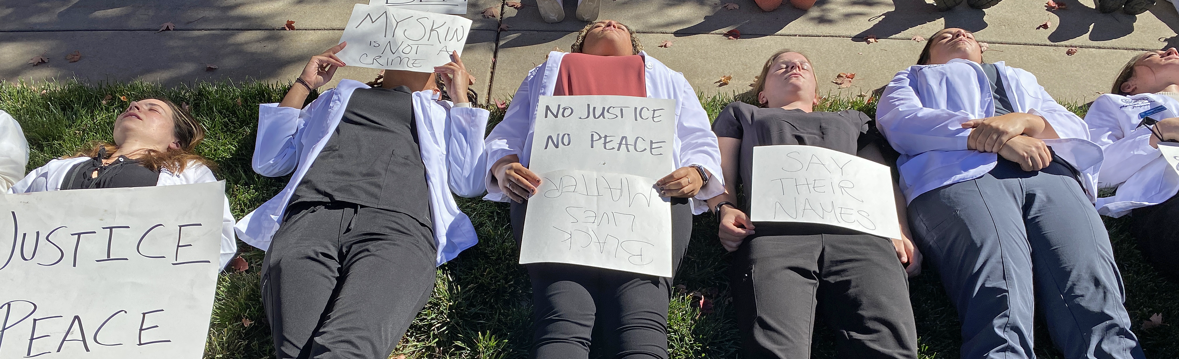White Coat for Black Lives Die-In participants lie on the ground
